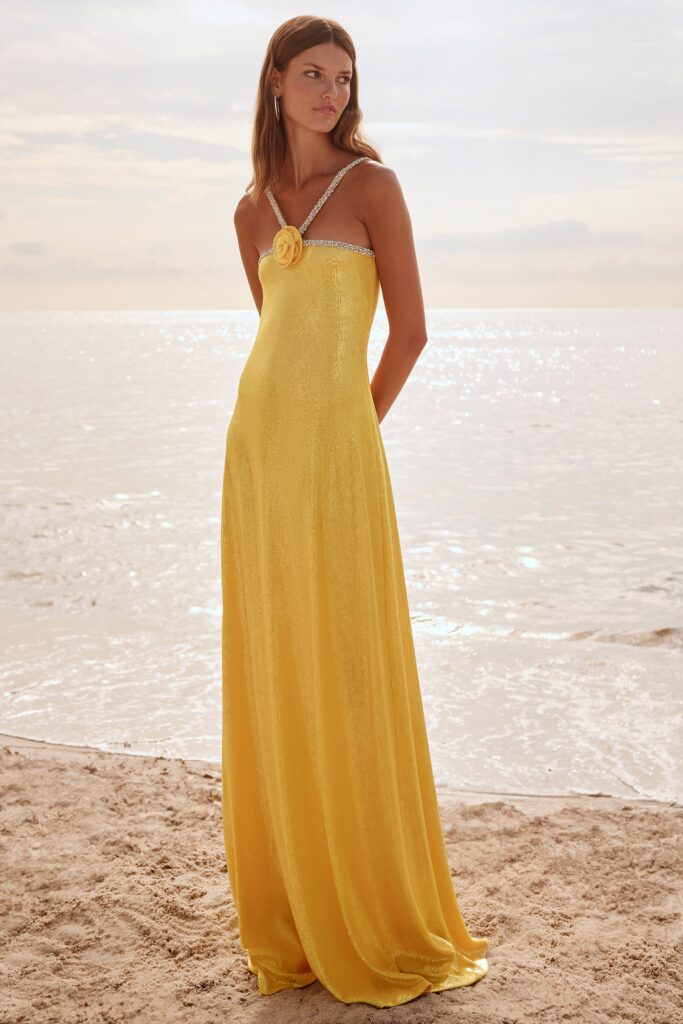 A fitted yellow silk gown with a sleeveless design and a maxi silhouette.