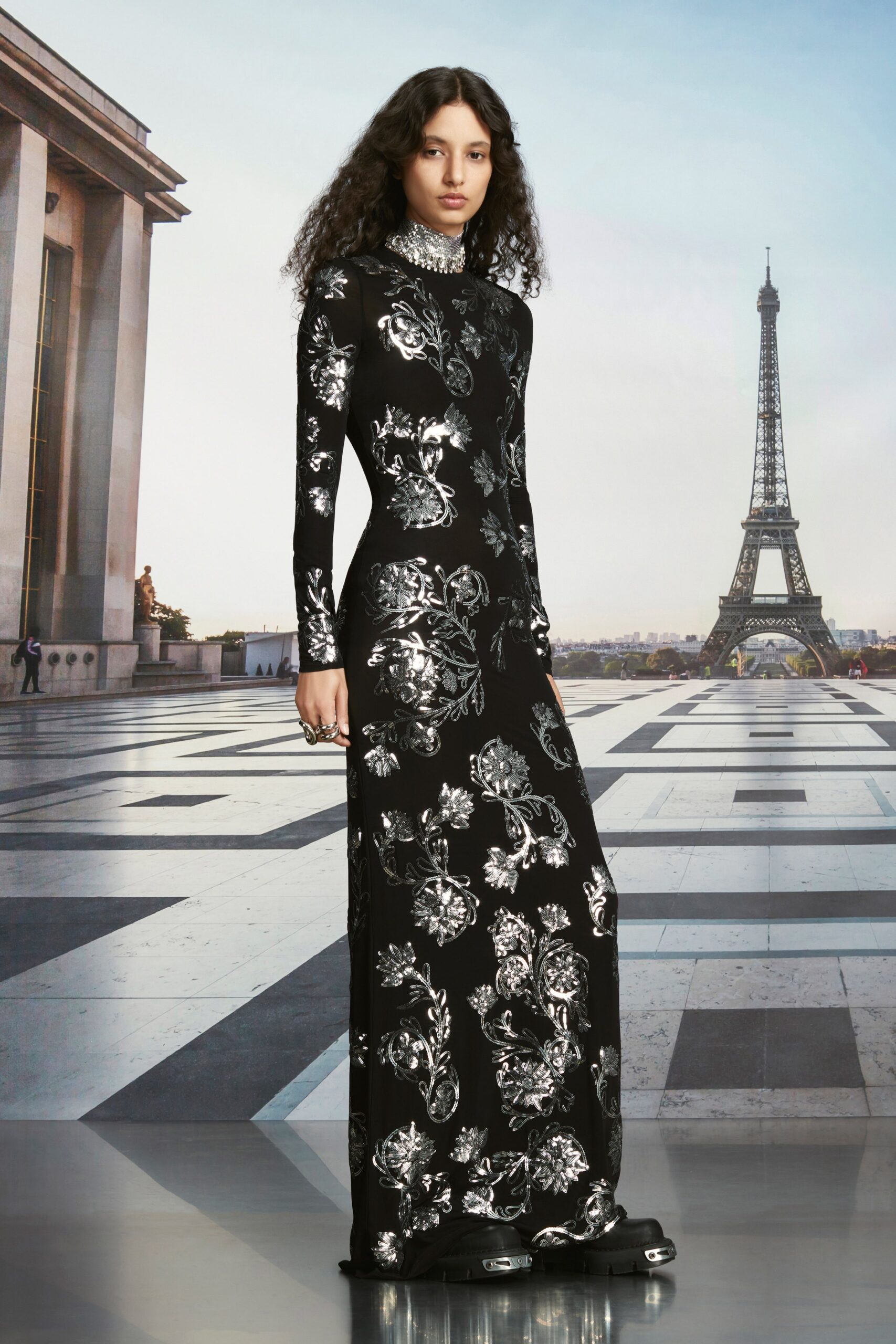 A fitted black silk gown with long sleeves, a high neckline, and a floral print.