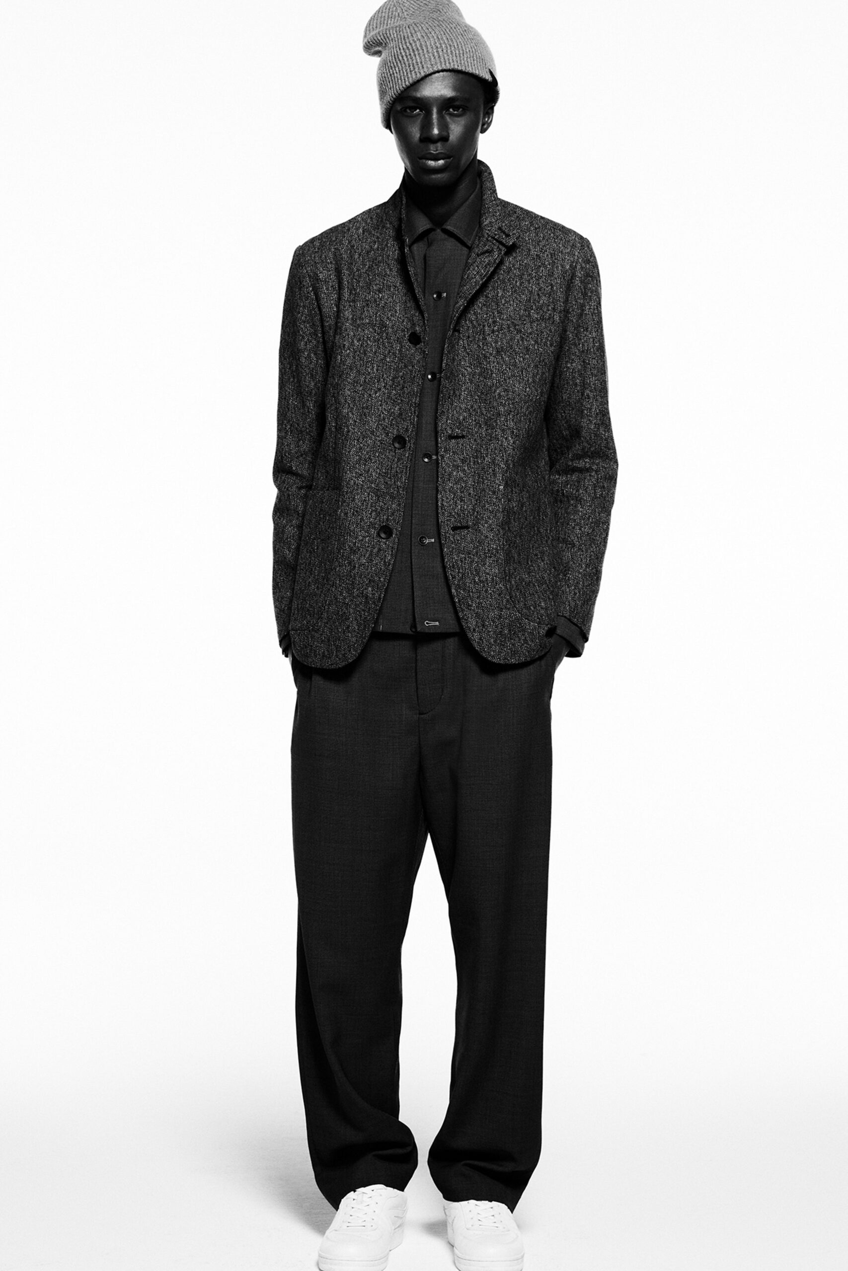 A relaxed-fit gray wool jacket with a collared neckline paired with black pants.