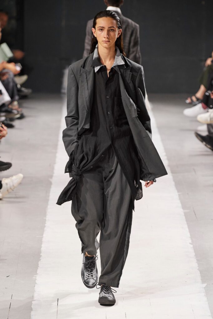 A relaxed black cotton suit featuring a long-sleeve collared shirt and wide-leg trousers.