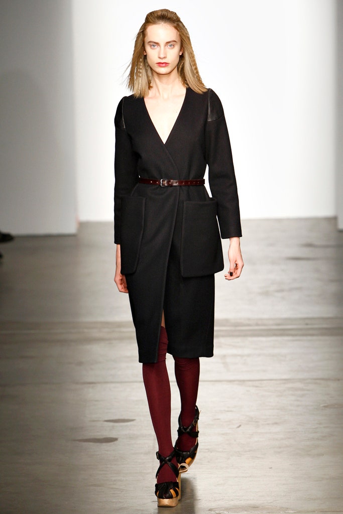 A fitted black wool dress with long sleeves, a V-neckline, and belted detail.