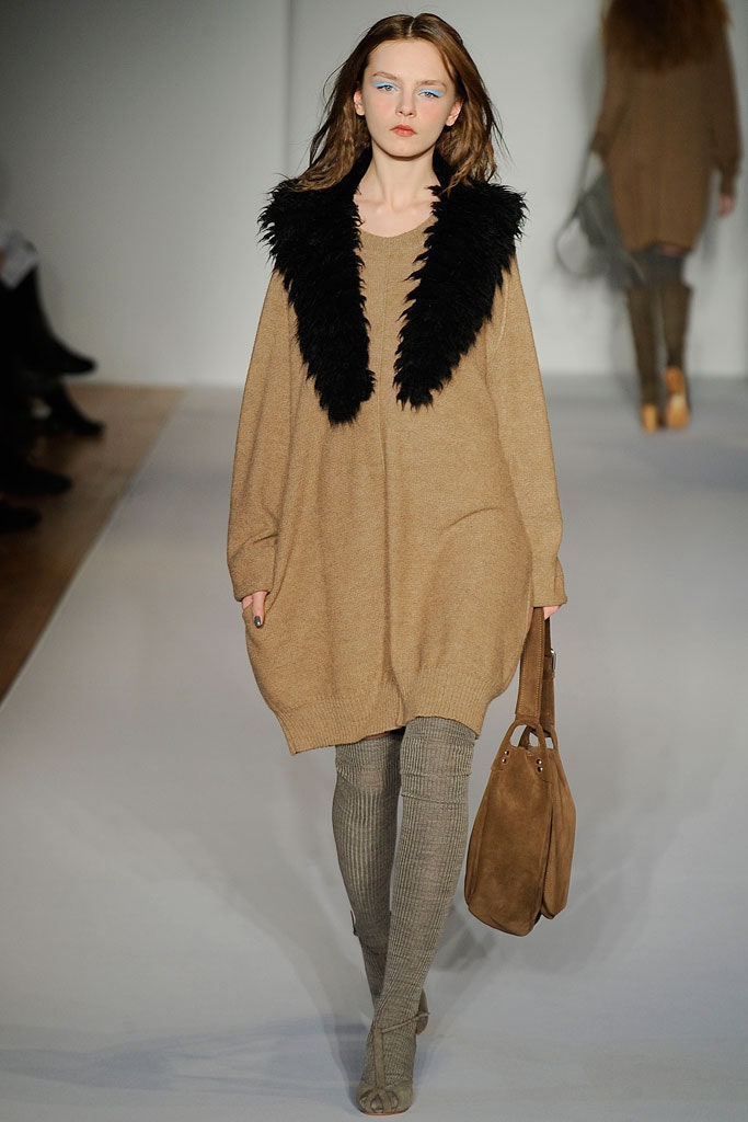 An oversized beige wool dress with long sleeves and a layered design detail.
