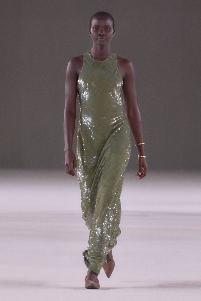 A fitted green sequin dress with a sleeveless design and high-neck construction, featuring a maxi silhouette.
