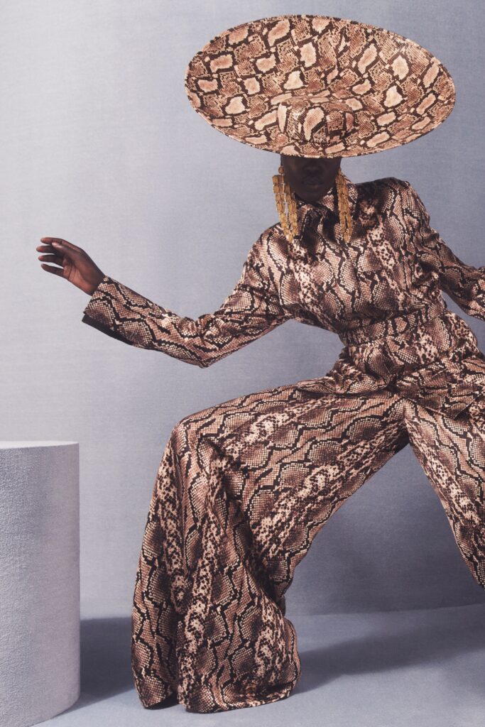 A relaxed brown printed silk jumpsuit with long sleeves and a collared neckline.