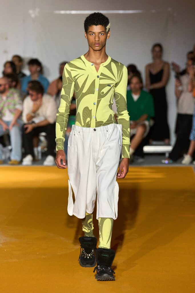 A relaxed fit green printed long-sleeve top paired with white relaxed pants.
