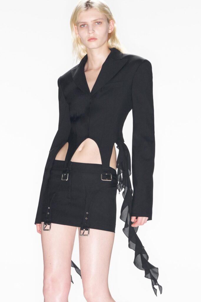 A fitted black blazer with an asymmetric design paired with a matching skirt.