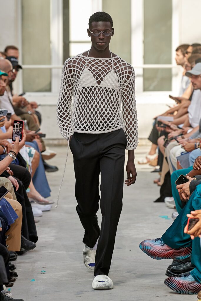 A relaxed black and white long-sleeve top with a V-neck and layered design paired with black pants.