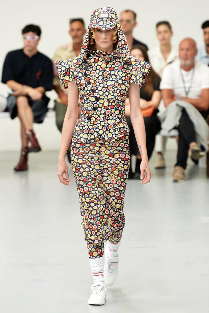 A fitted multicolor dress with a high neckline and floral print design.