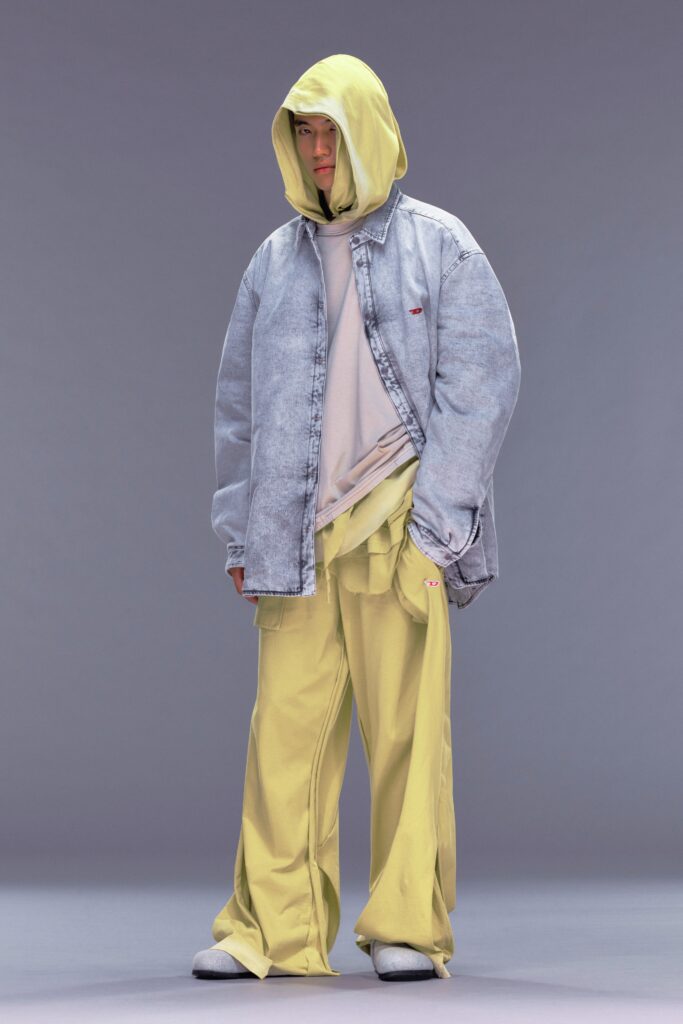 A relaxed gray denim jacket with a hood paired with layered yellow pants.