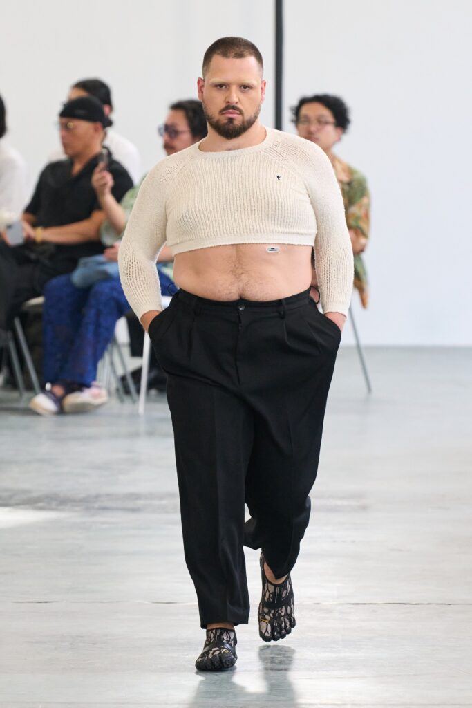 A fitted beige cropped top paired with high-waisted black pants for a modern look.