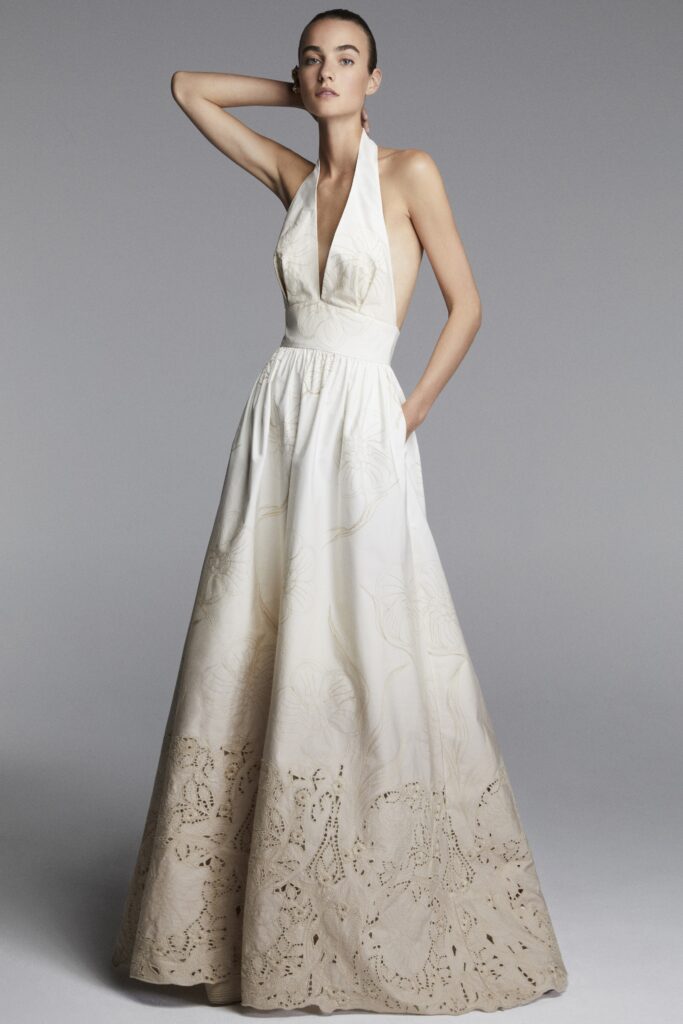 A fitted white silk sleeveless gown with a halter neckline and a flowing maxi silhouette.