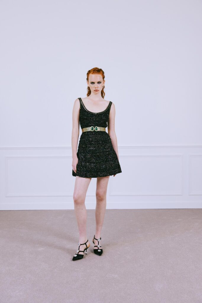 A fitted black cotton sleeveless dress with a V-neckline and A-line silhouette.