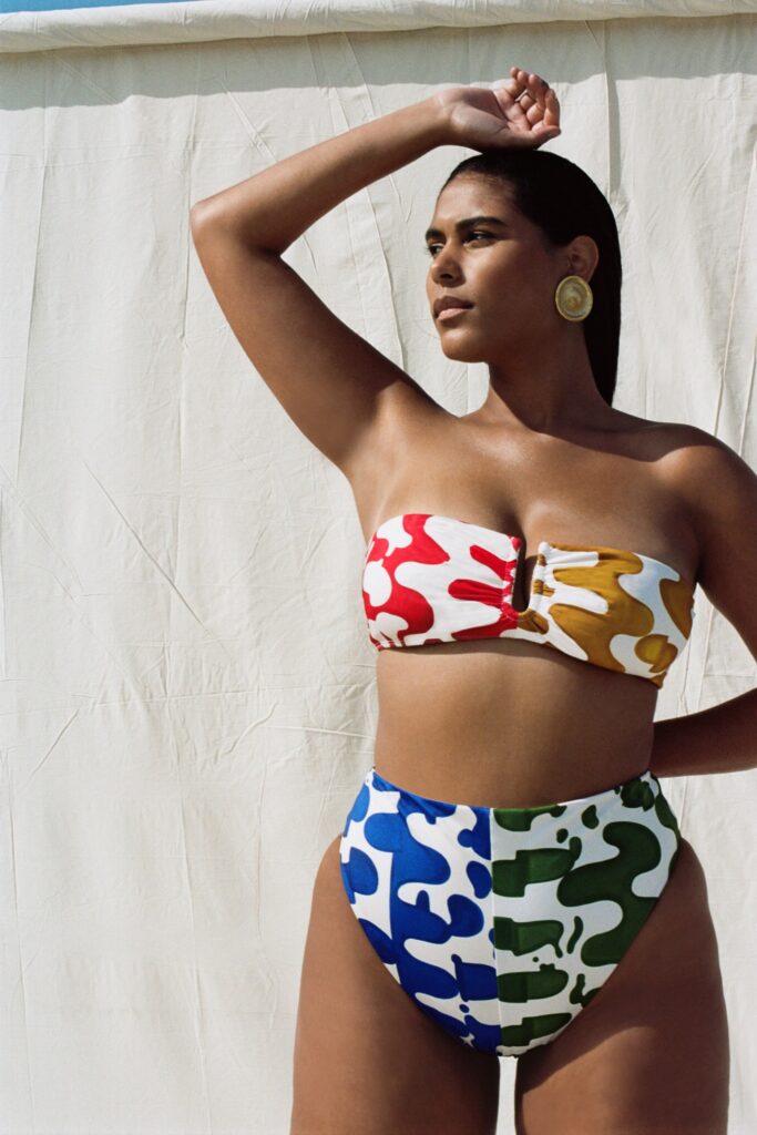 A fitted color-blocked strapless bikini featuring vibrant red, yellow, blue, and green hues.