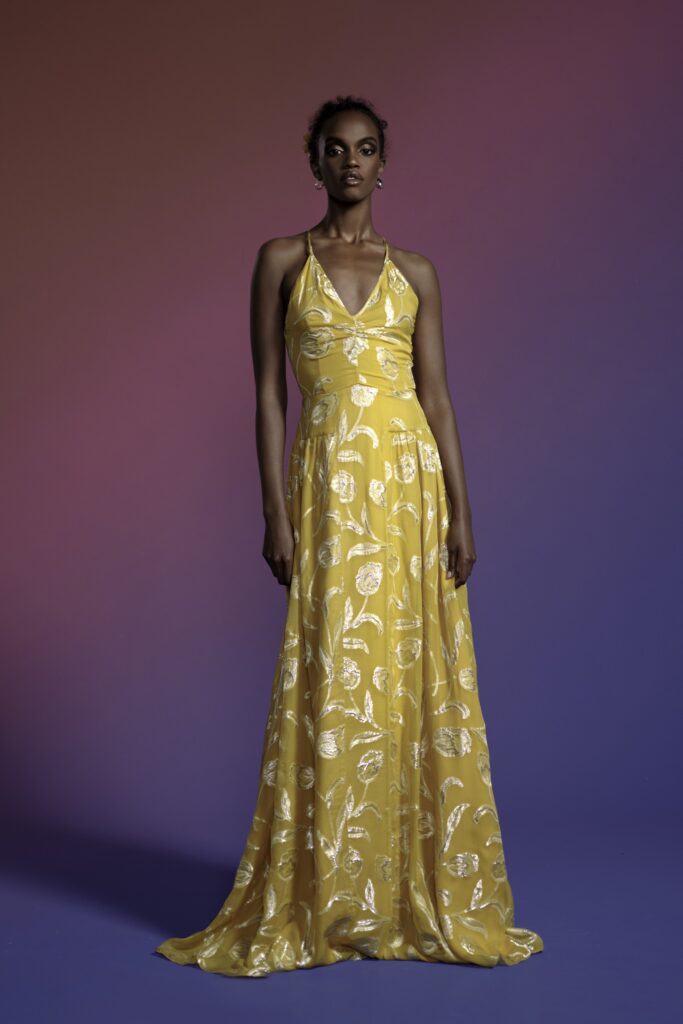 A fitted yellow silk sleeveless gown with a V-neckline and flared silhouette.