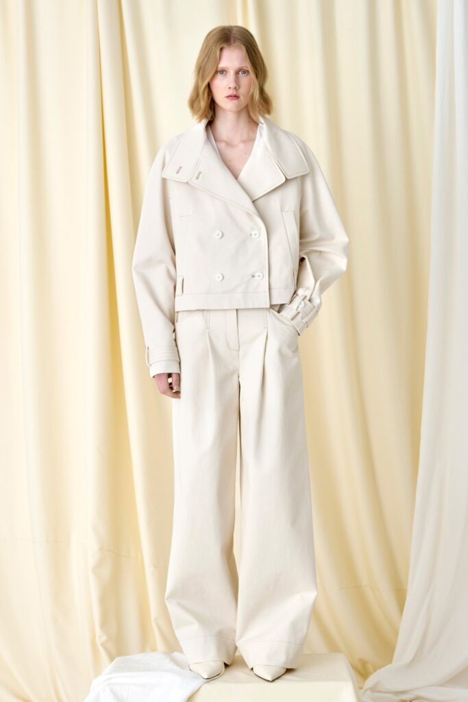 A relaxed white jacket with long sleeves and a collared design paired with wide-leg pants.
