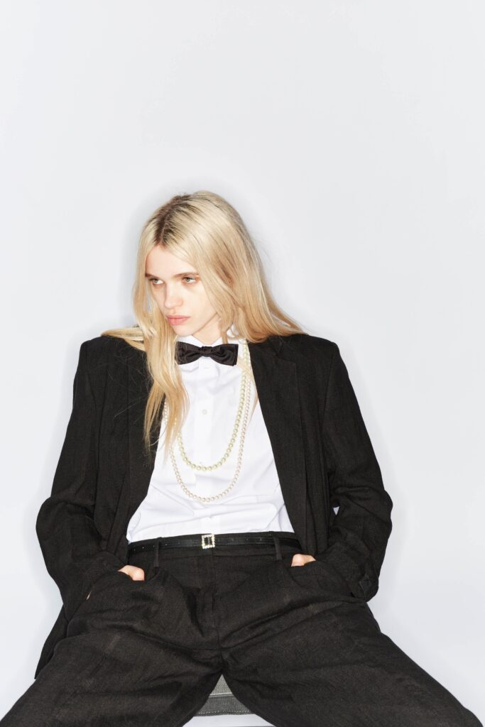 A relaxed black blazer paired with white collared shirt and straight-leg pants.