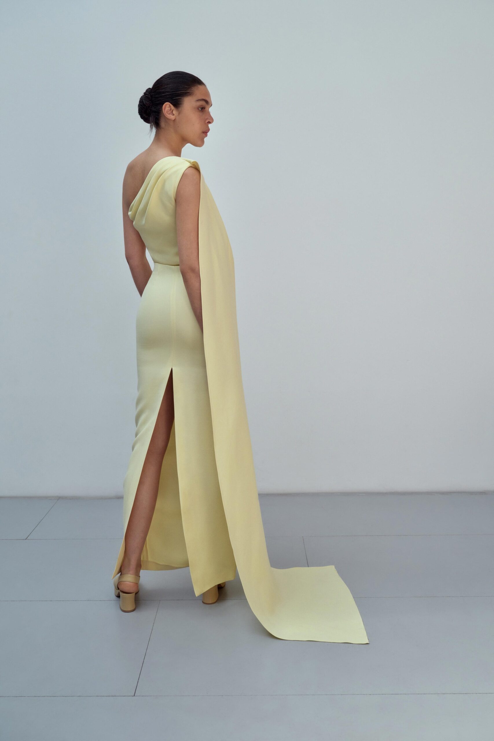 A fitted yellow silk dress with a sleeveless design and a high slit.