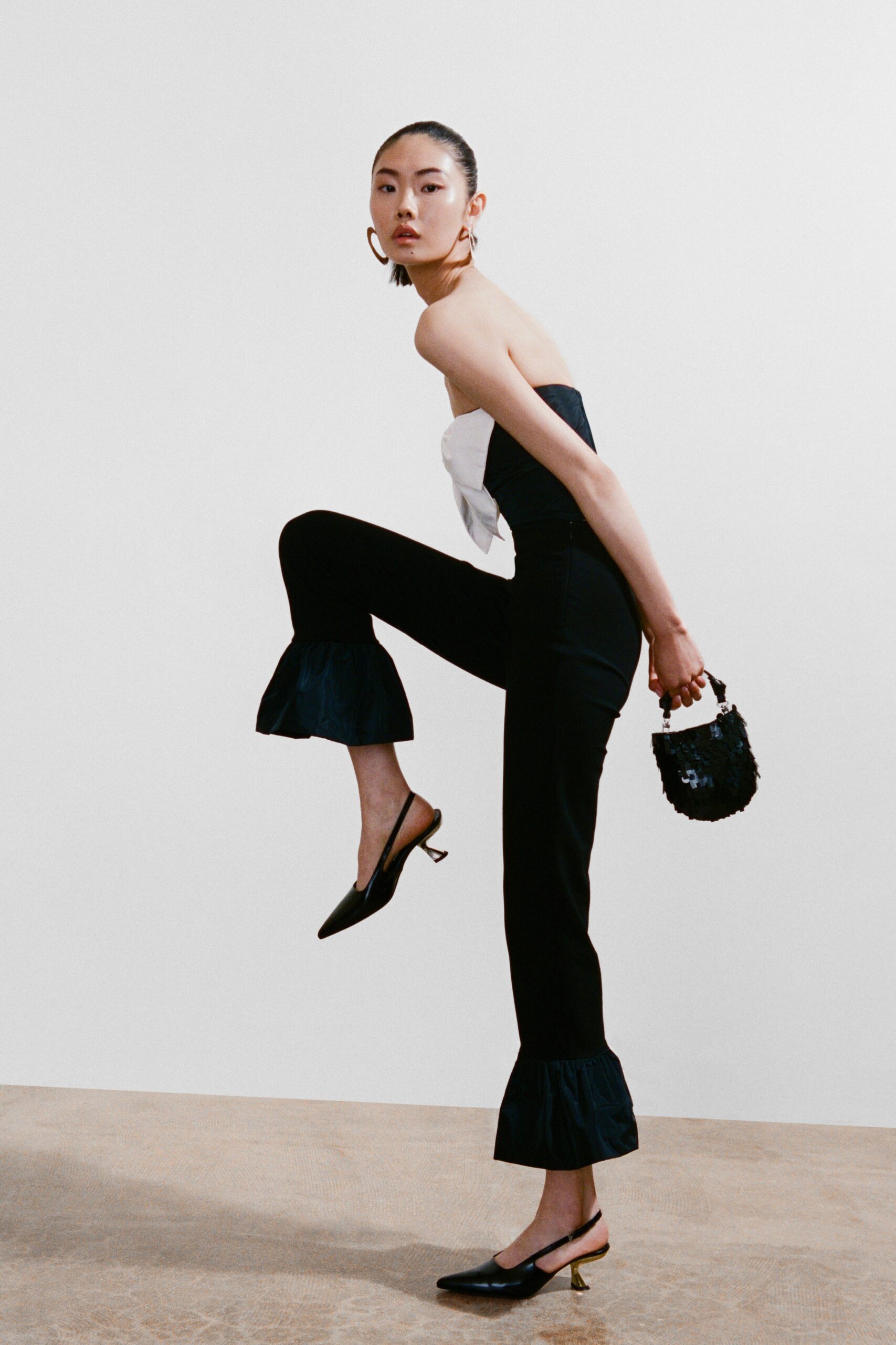 A fitted black and white sleeveless jumpsuit with a V-neckline and flared legs.