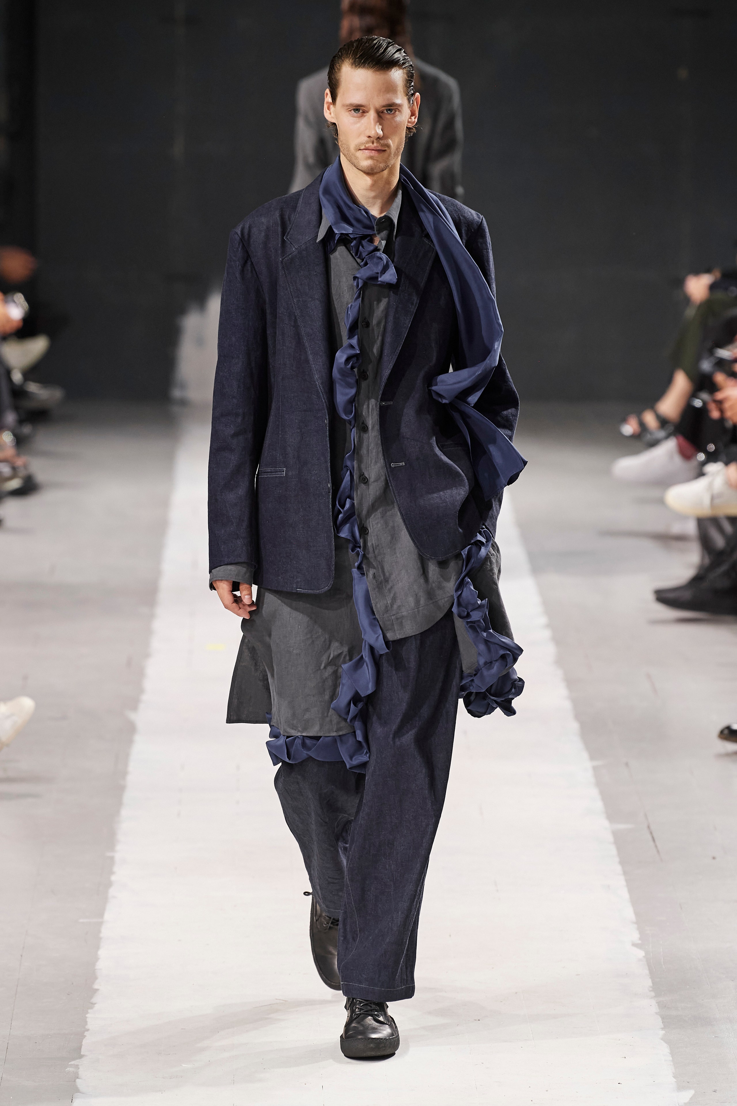 A relaxed blue cotton suit featuring long sleeves, a collared design, and layered fringed details.