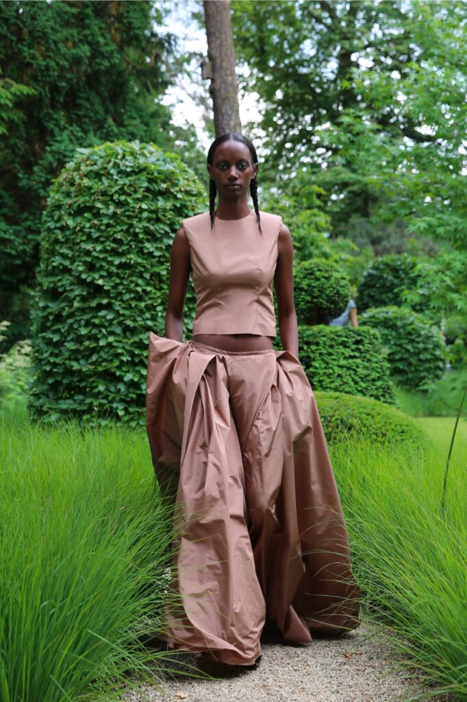 A fitted brown cotton sleeveless top paired with an asymmetric layered skirt.