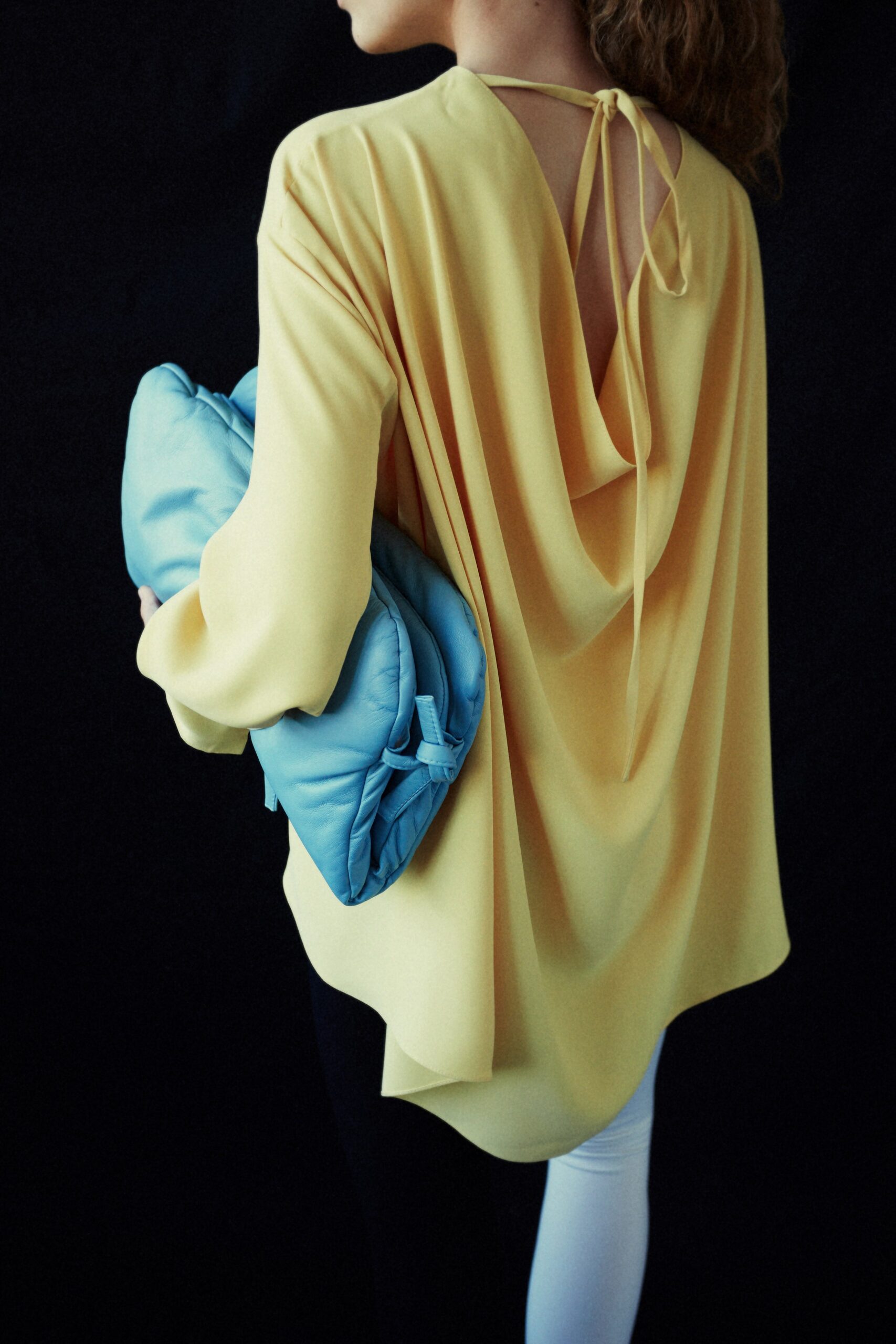 yellow draped top with blue bag