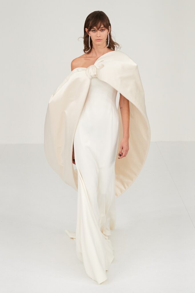 A fitted white silk strapless gown with a draped design detail.