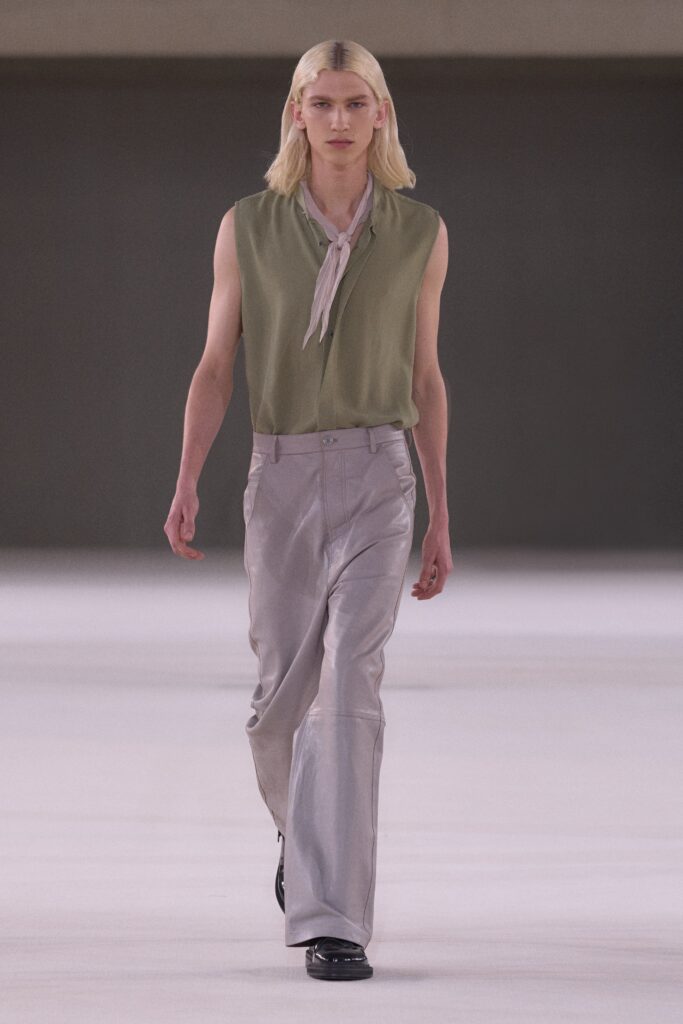 A relaxed green silk sleeveless top paired with gray leather straight-leg pants.