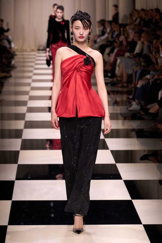 red draped top with black pants