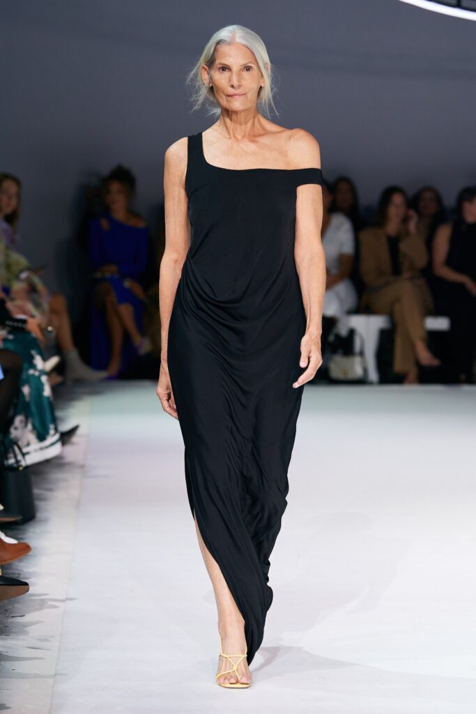 A relaxed black silk sleeveless dress with an asymmetric design and draped detail.