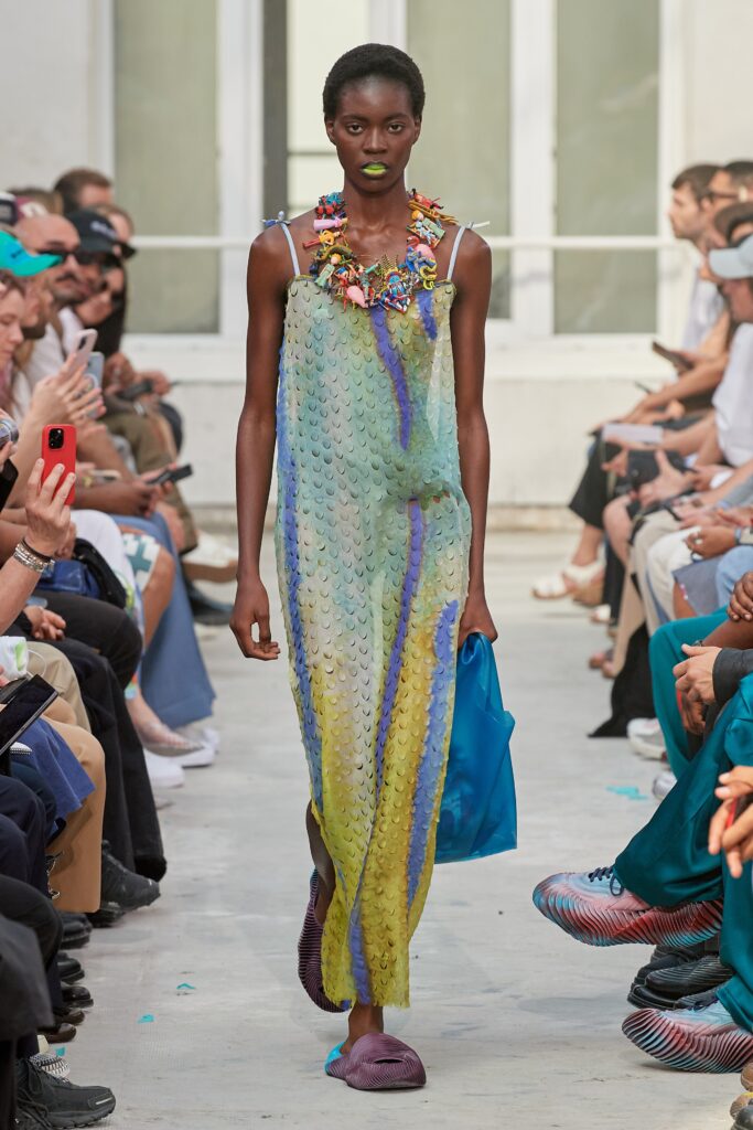 A relaxed sleeveless dress in blue, green, and yellow silk with an asymmetric design.