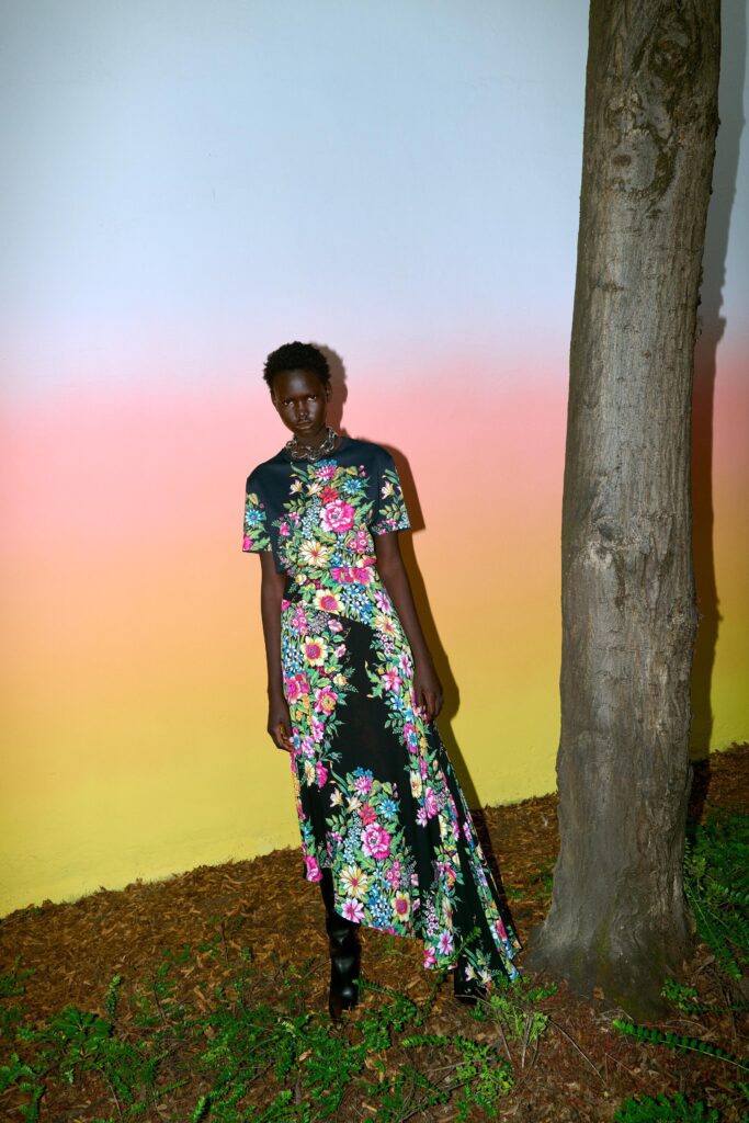 A fitted black floral maxi dress with short sleeves and a collared neckline.