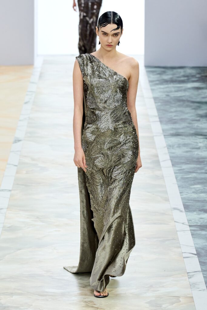 A fitted green silk gown with an embroidered design and sleeveless high-neck construction.