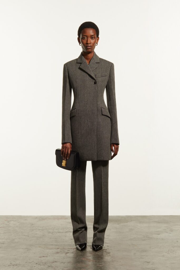 A tailored gray wool suit with long sleeves and a collared design, featuring straight-leg trousers.