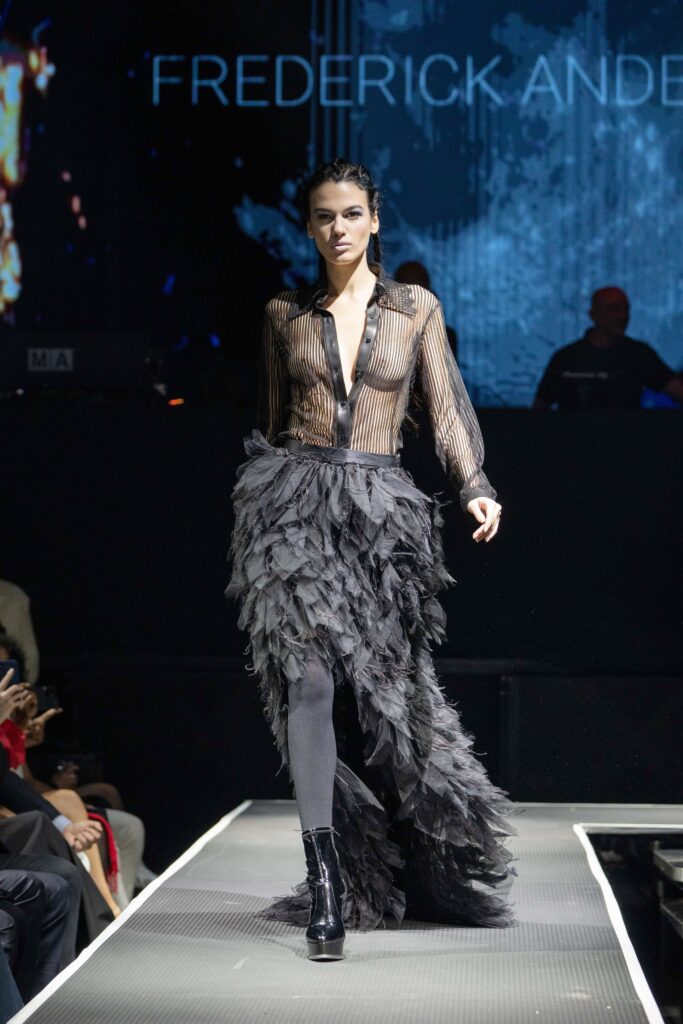 A fitted black silk long-sleeve dress with a V-neckline and tiered design.