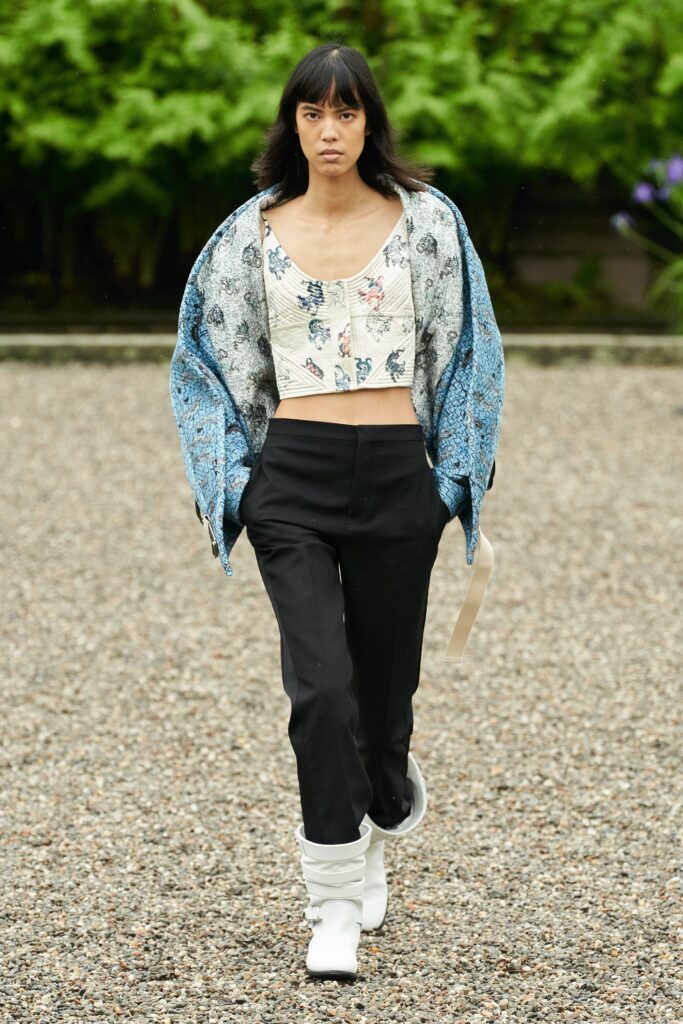 A fitted blue floral cropped top paired with black pants, showcasing a modern and stylish look.
