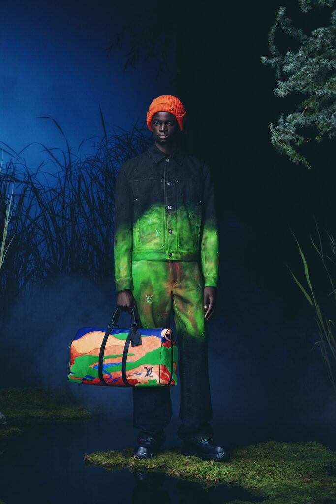 A relaxed black denim jacket paired with printed pants in green and orange hues.