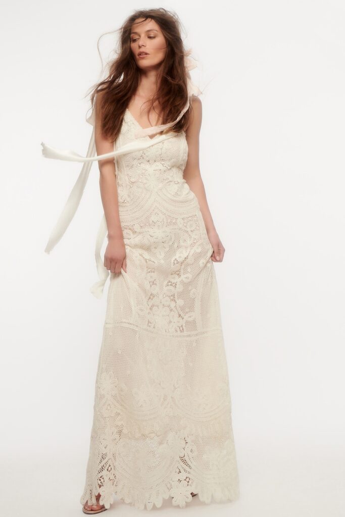 A fitted cream lace sleeveless dress with a V-neckline and maxi length.