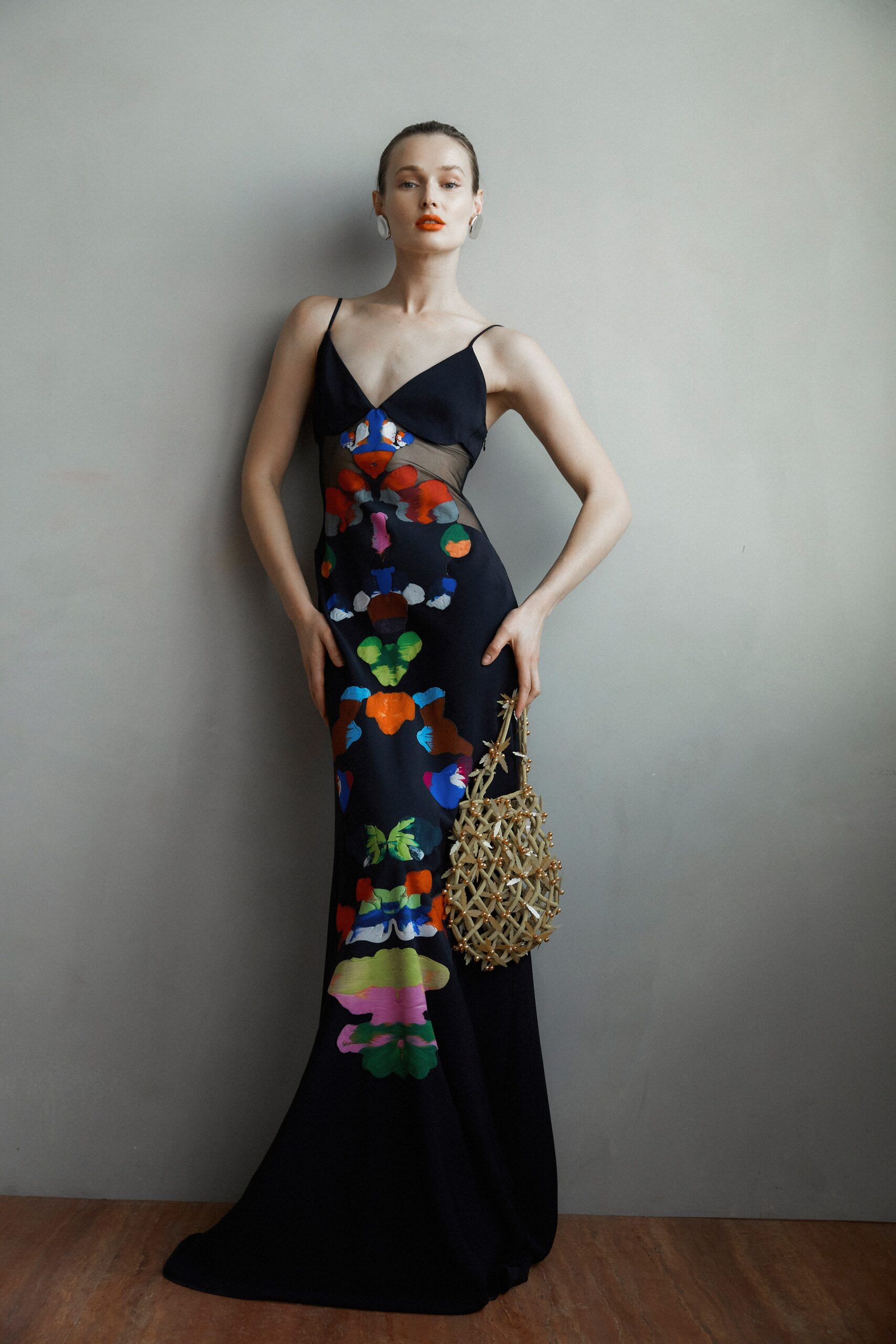 A fitted black silk dress with a V-neckline and vibrant floral print.
