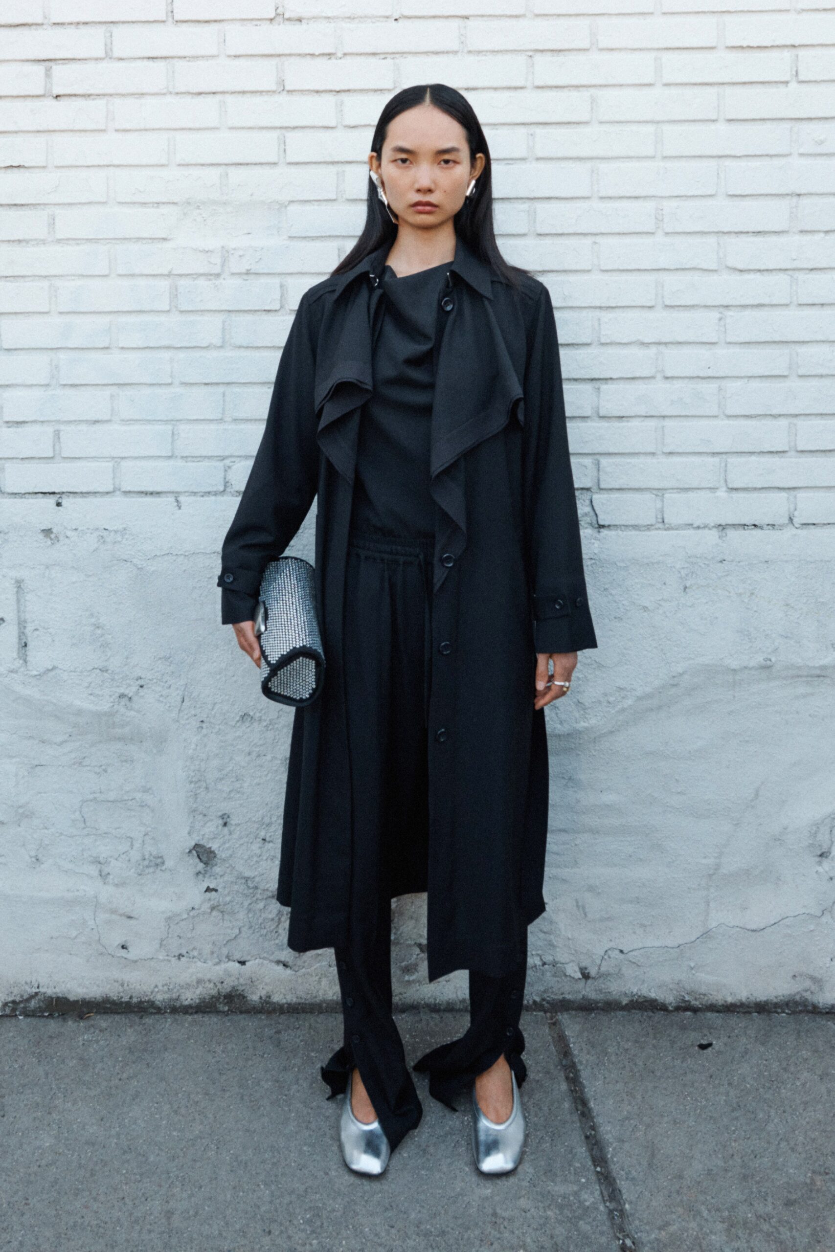 A relaxed black coat with long sleeves and a collared design, paired with matching pants.