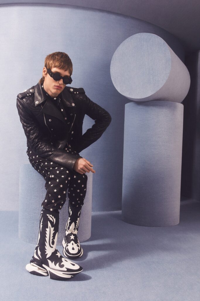 A fitted black leather jacket paired with black and white printed pants, creating a bold fashion statement.