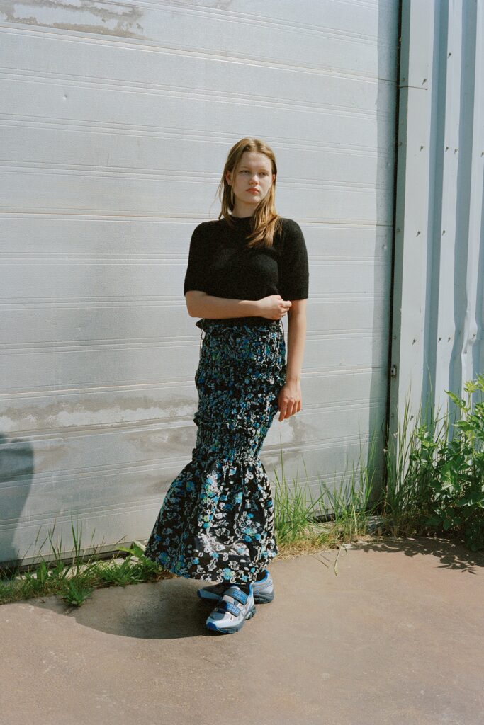 A fitted black short-sleeve top paired with a high-waisted flared skirt in blue floral print.
