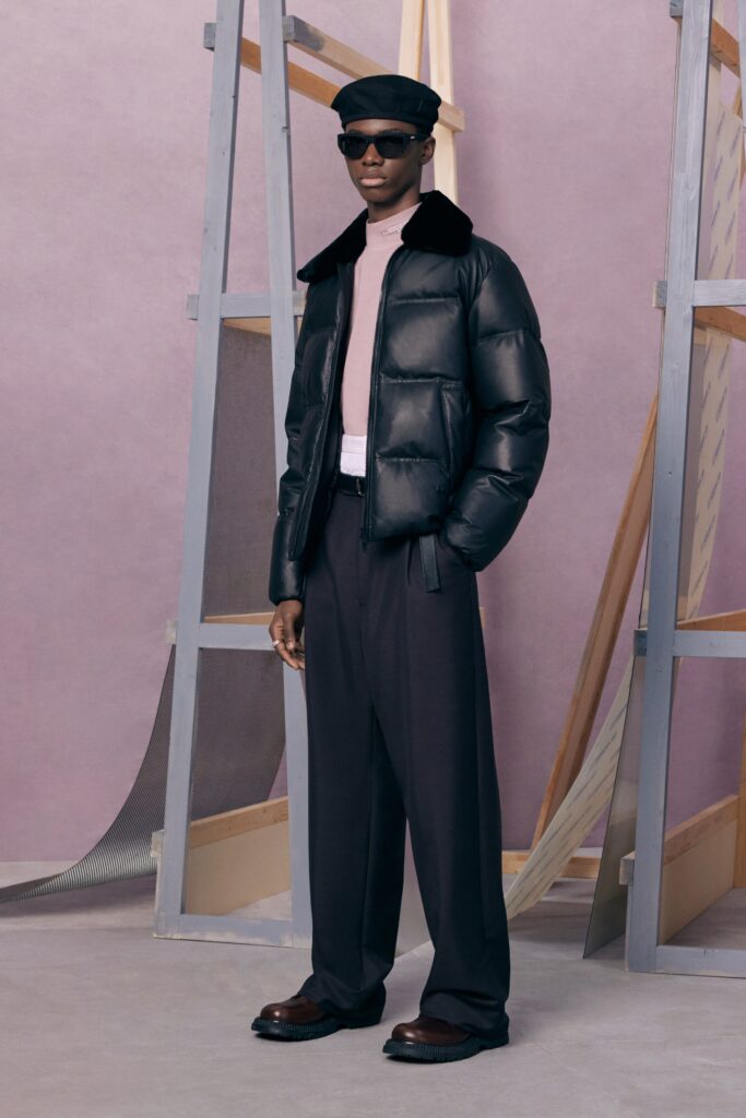 An oversized black leather jacket paired with pink cotton pants, creating a stylish and modern look.