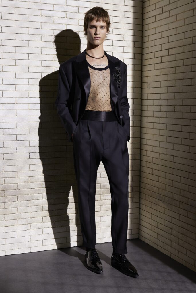A tailored black silk suit featuring a collared long-sleeve shirt and buttoned design details.