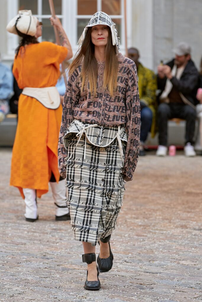 A relaxed brown printed top with long sleeves paired with an asymmetric printed skirt.