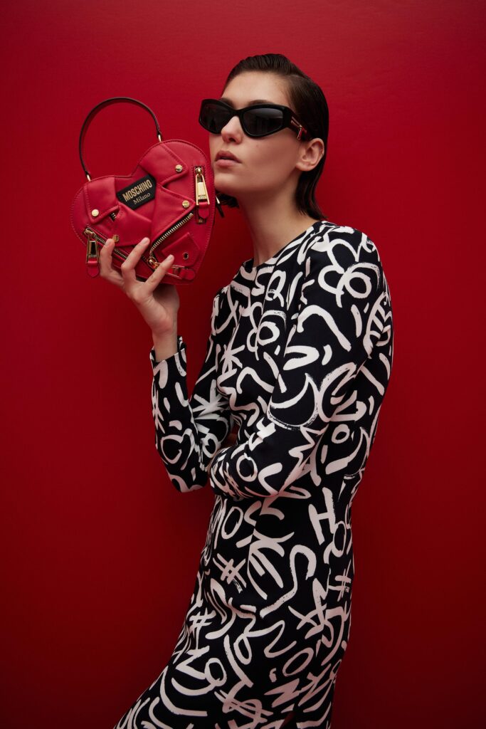 A fitted black and white printed dress with long sleeves and a collared neckline.
