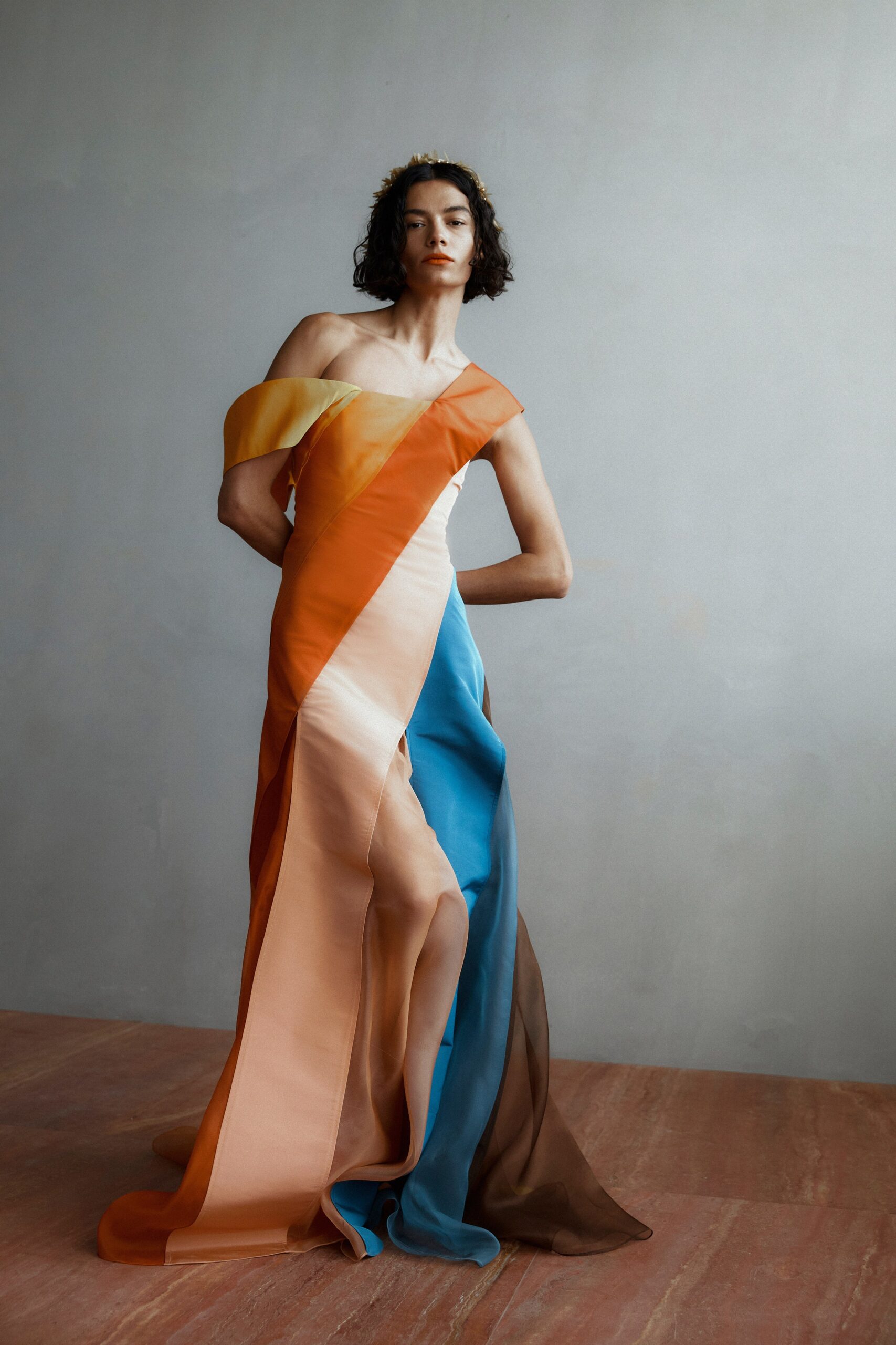 A fitted sleeveless silk dress featuring an asymmetric design with a slit.