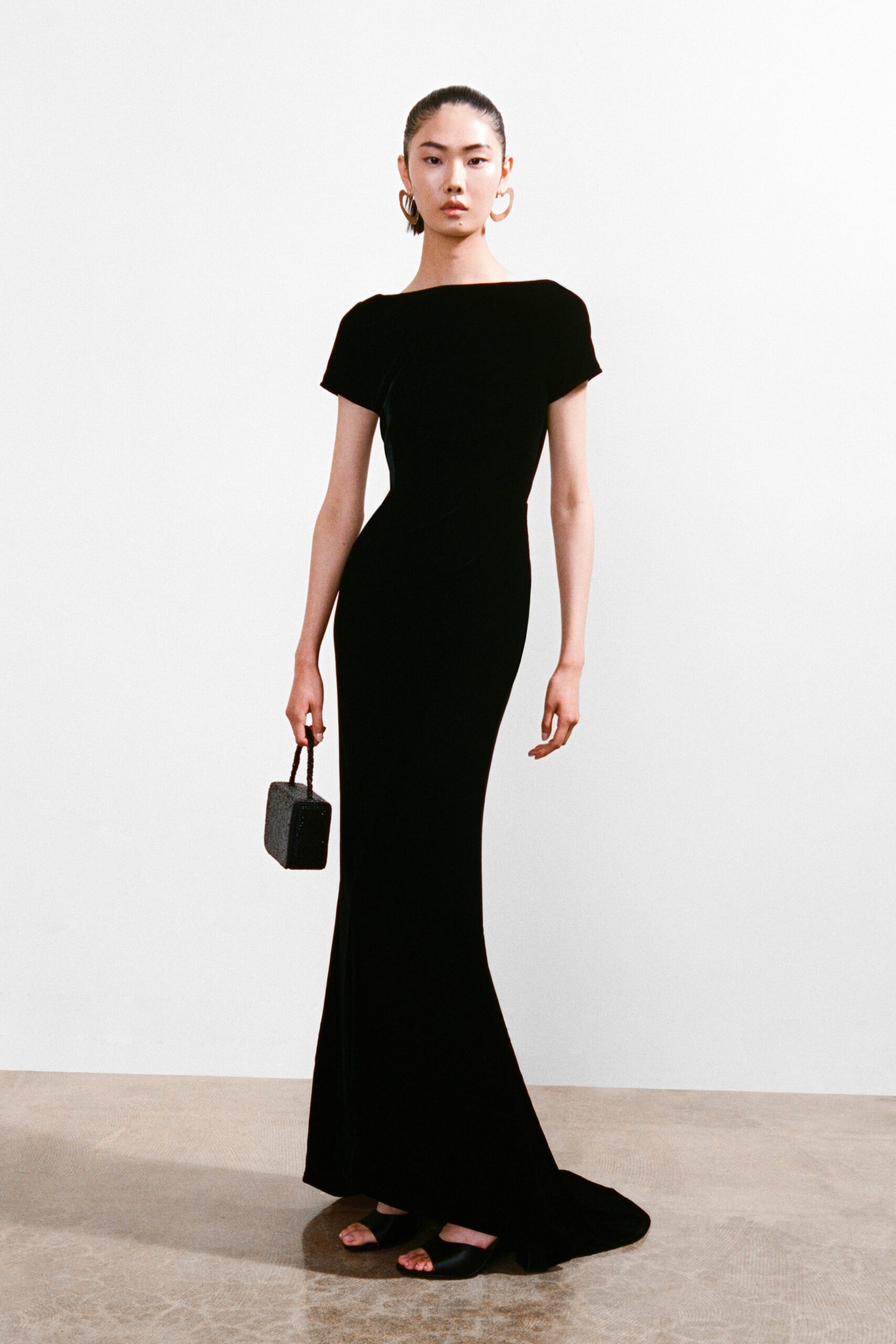A fitted black silk gown with a high neckline and short sleeves, perfect for formal occasions.