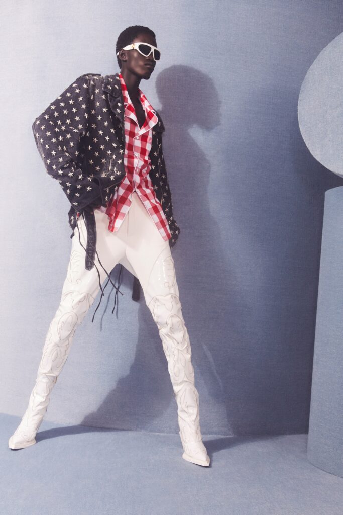 An oversized black denim jacket paired with white pants and a red checkered shirt.
