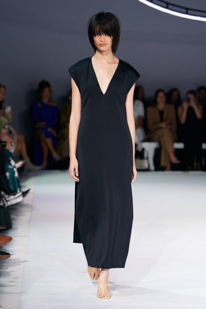 A relaxed black silk sleeveless dress featuring a deep V-neckline and maxi length.