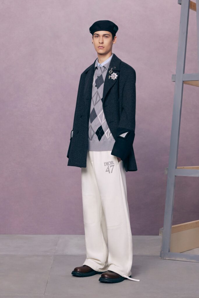 An oversized black wool coat paired with white tailored pants for a modern look.